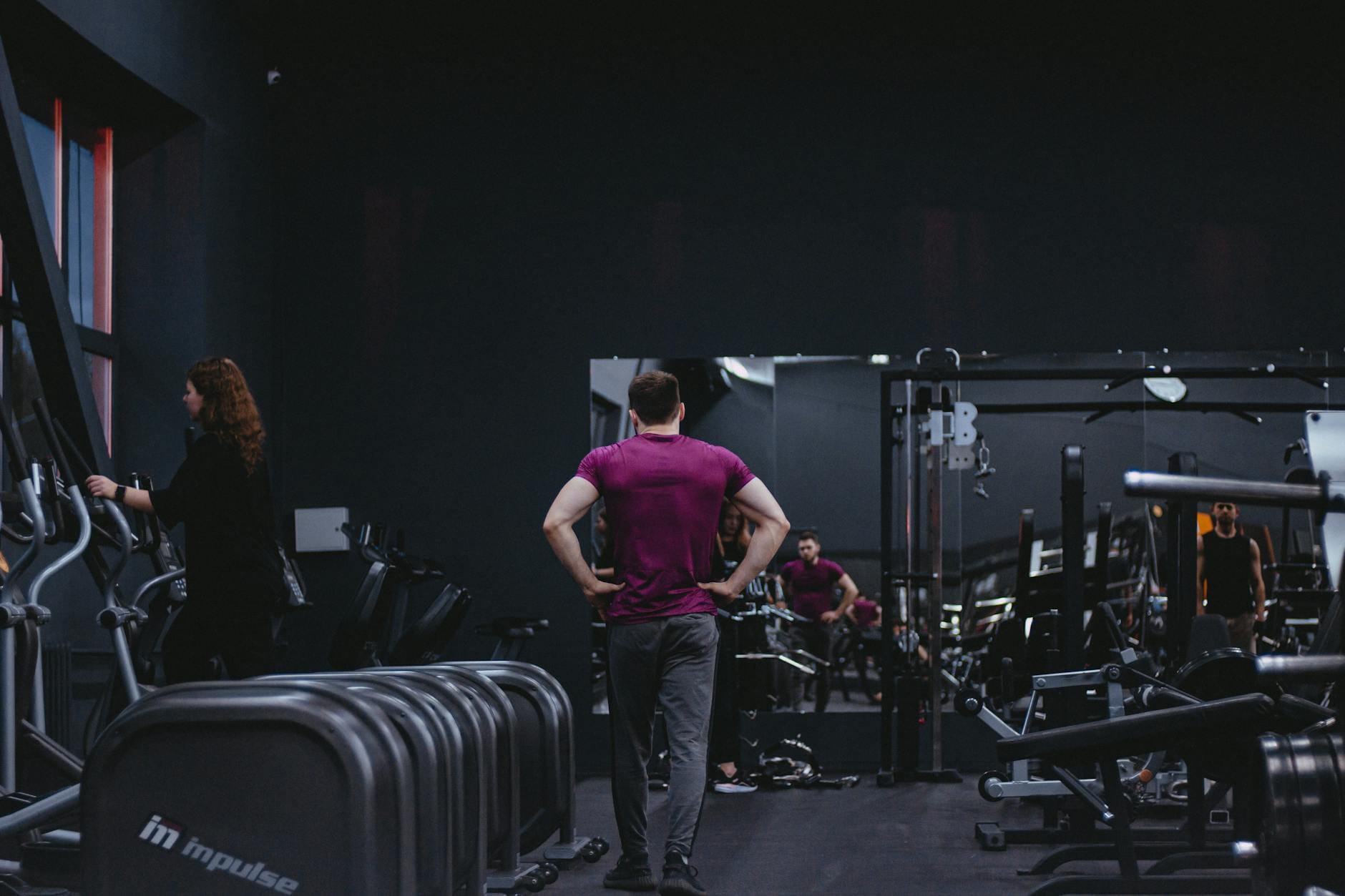 Mężczyzna ćwiczący na siłowni wśród sprzętu fitness