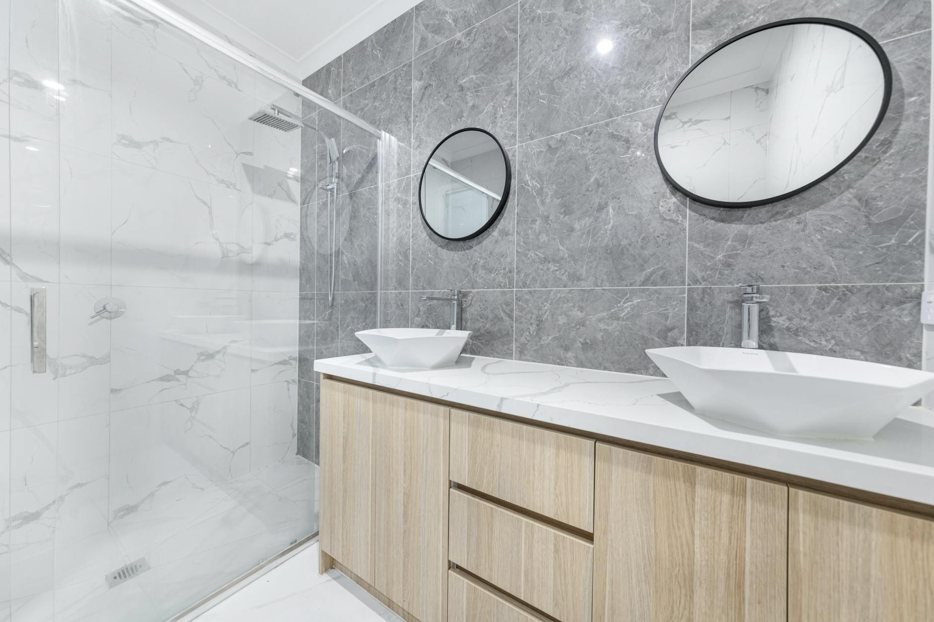 Nowoczesna łazienka po remoncie z dwiema umywalkami i marmurowymi płytkami