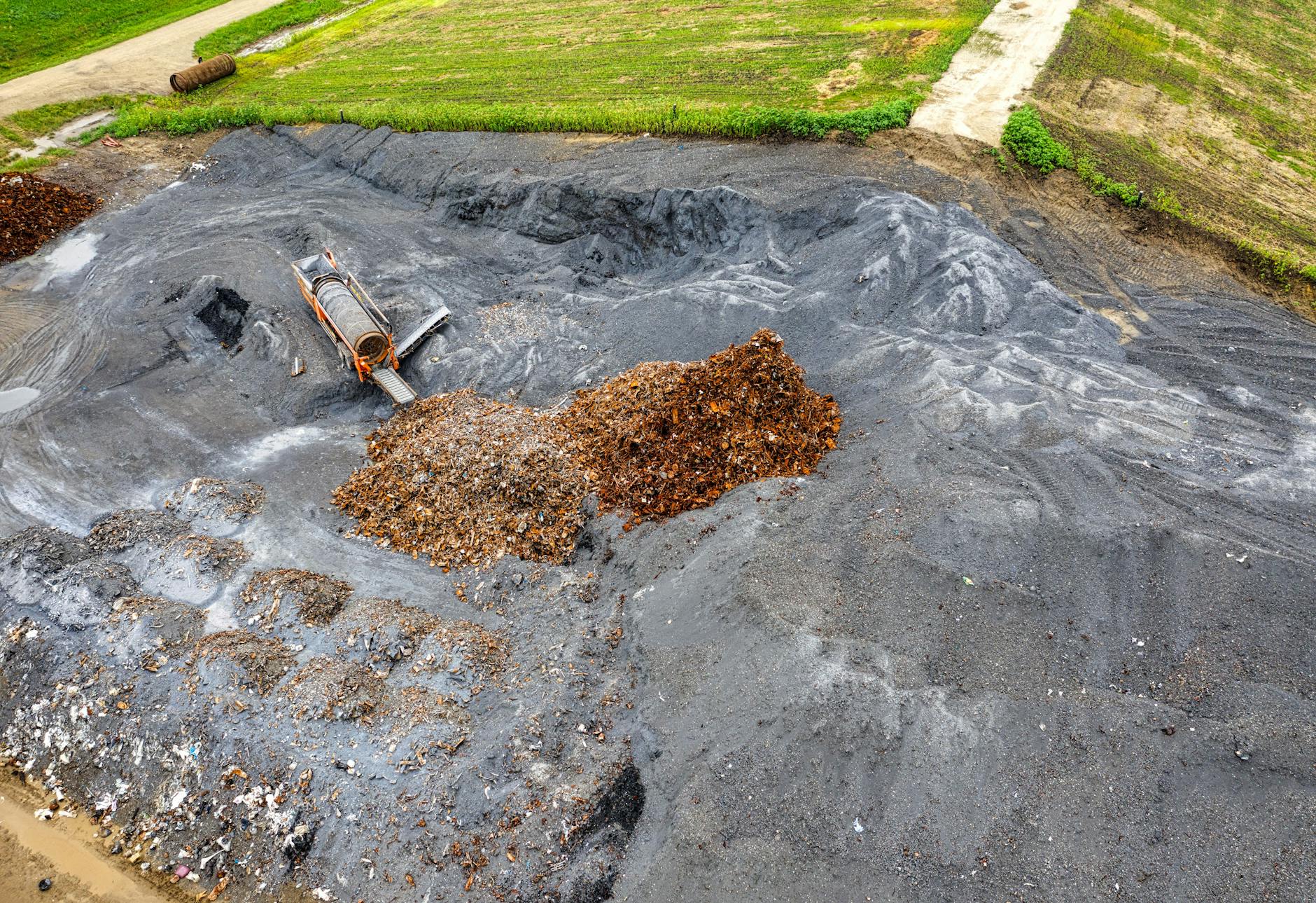 Stos odpadów na ciemnej ziemi sfotografowany z lotu ptaka