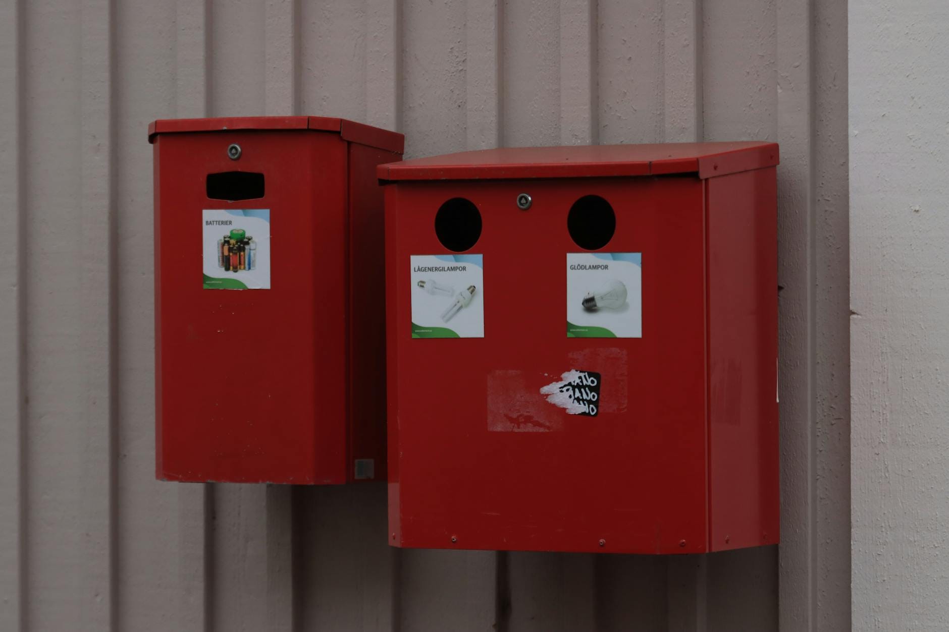 Czerwone miejskie pojemniki do recyklingu baterii i żarówek