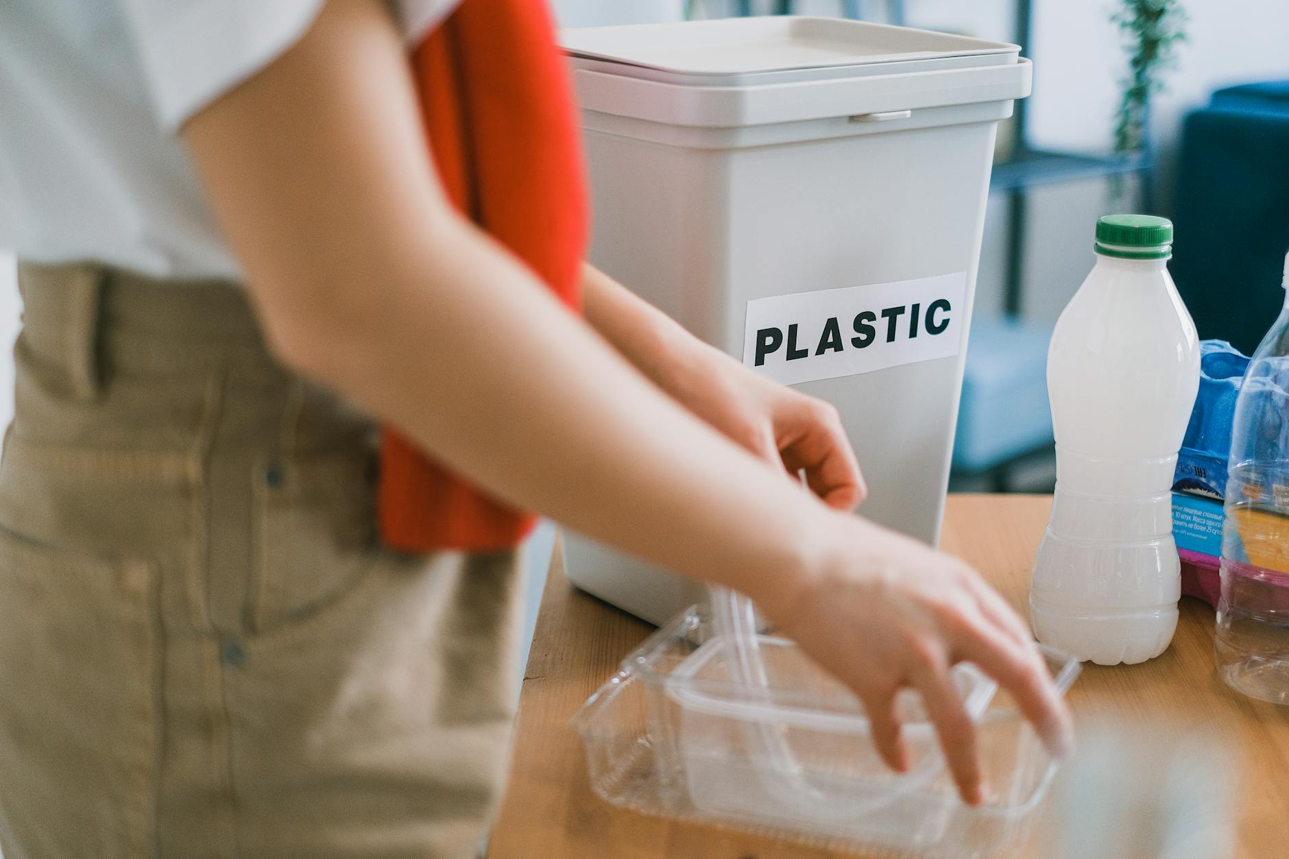 Kobieta w domu segreguje plastikowe odpady do pojemnika