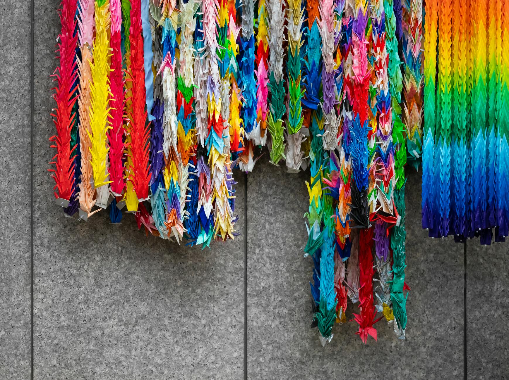 Kolorowe żurawie origami wiszące na ścianie w Tokio