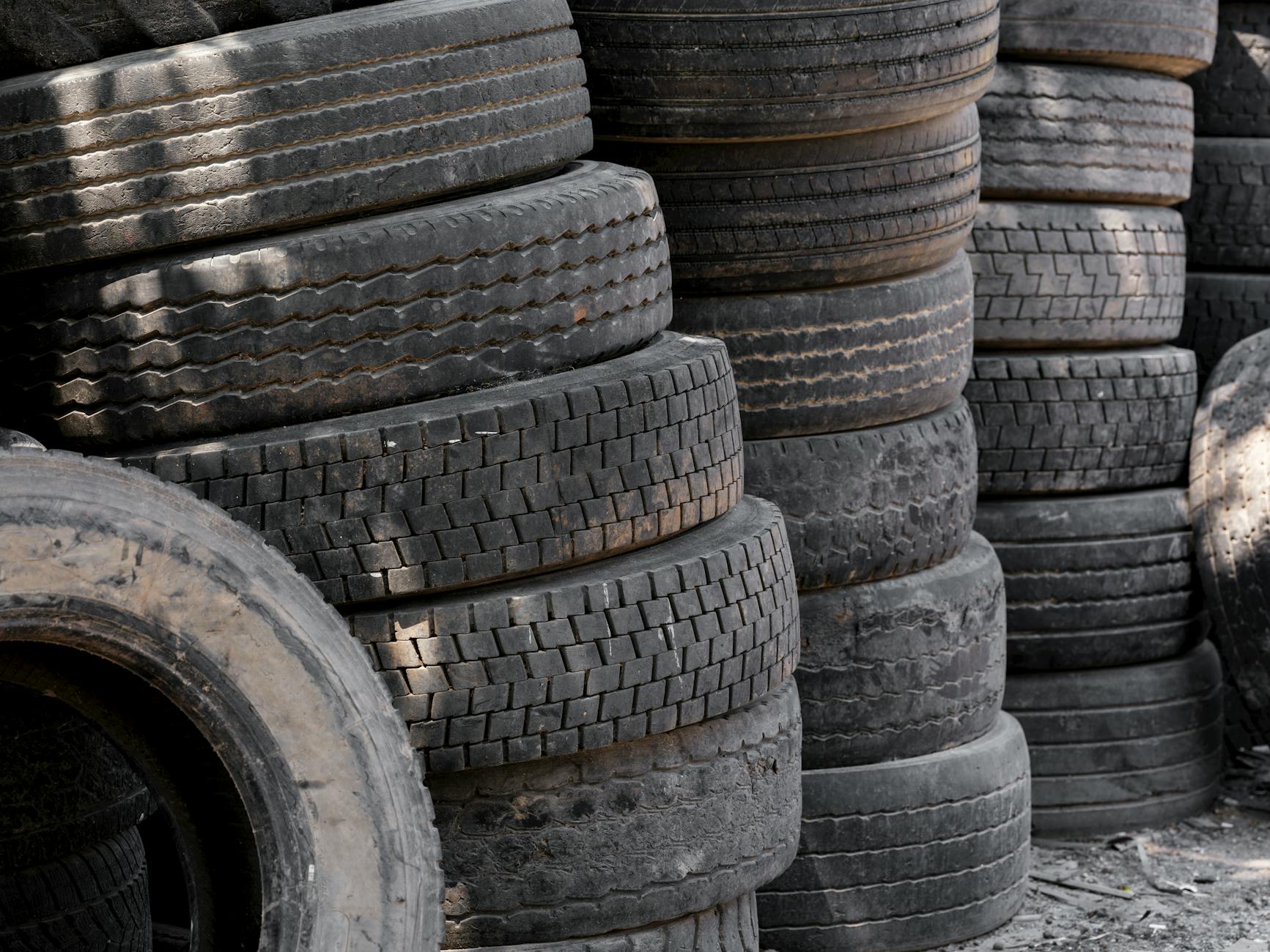 Stos starych opon samochodowych przygotowanych do recyklingu na placu
