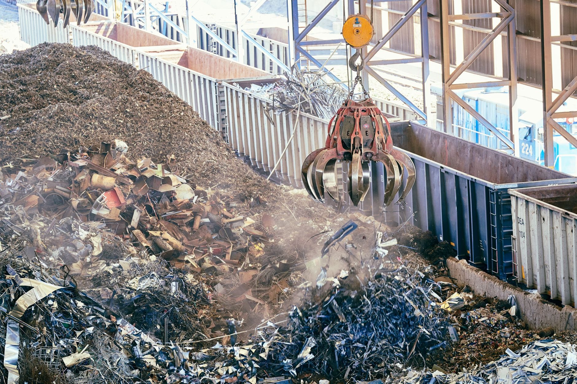 Złom metalowy przetwarzany przez ciężką maszynę w zakładzie recyklingu